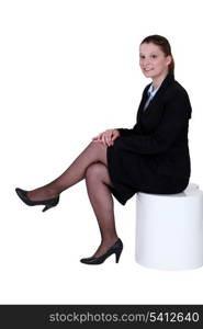 Young woman in smart suit sitting on a stool