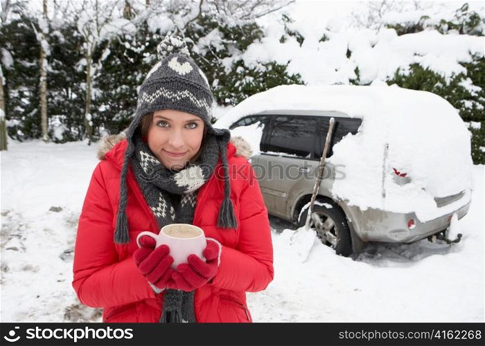 Young woman in snow with car