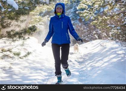 Young woman in  snowy forest  at sunny winter day