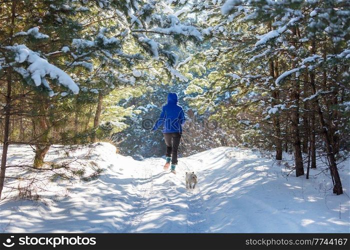 Young woman in  snowy forest  at sunny winter day
