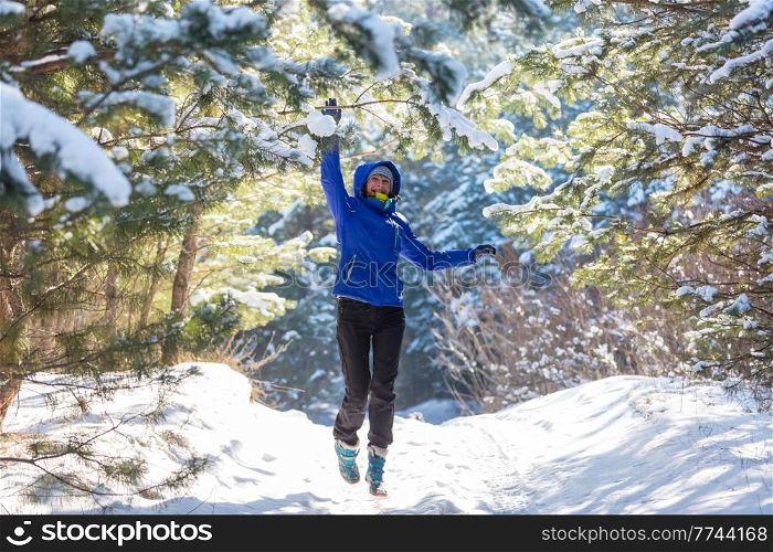 Young woman in snowy forest at sunny winter day