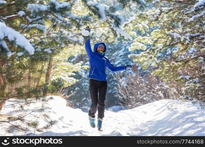 Young woman in snowy forest at sunny winter day