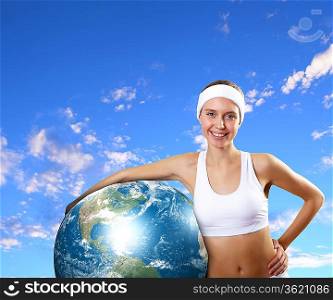 Young woman in sport wear with a model of our planet. Elements of this image are furnishes by NASA