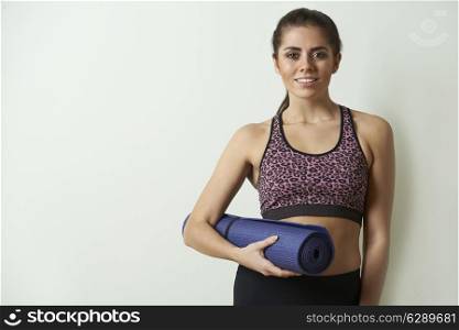 Young Woman In Sportswear Carrying Exercise Mat