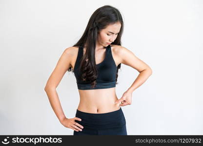 Young woman in sportswear touching her belly. Dieting and weight loss concept.. Young woman in sportswear touching her belly.