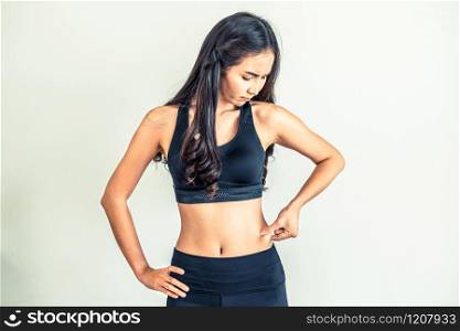 Young woman in sportswear touching her belly. Dieting and weight loss concept.