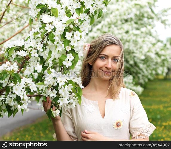 young woman in spring park among flowers