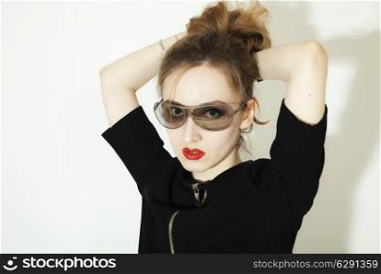 young woman in stylish sunglasses on a bright background