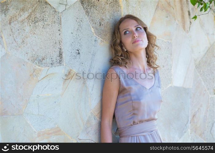 Young Woman in Summer Dress Against Old Stone Wall, Outdoor Shot