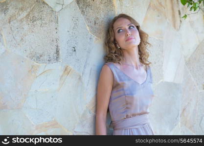 Young Woman in Summer Dress Against Old Stone Wall, Outdoor Shot