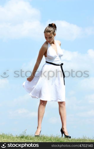 Young woman in summer dress on a background of the blue sky