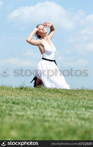 Young woman in summer dress on a background of the blue sky