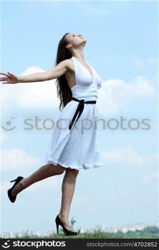 young woman in summer dress on a background of the blue sky