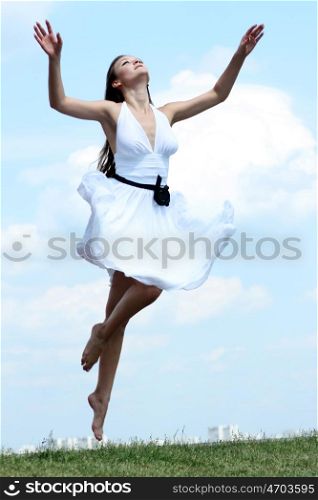 Young woman in summer dress on a background of the blue sky