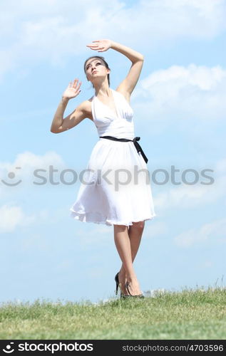 Young woman in summer dress on a background of the blue sky