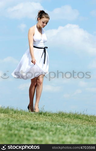 Young woman in summer dress on a background of the blue sky