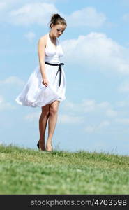 Young woman in summer dress on a background of the blue sky