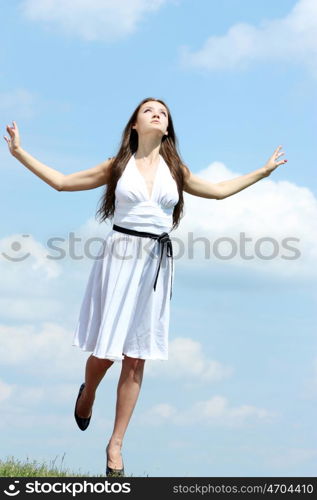 Young woman in summer dress on a background of the blue sky