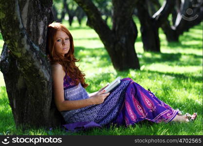 young woman in summer, green park reading book