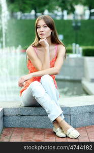 Young Woman in summer sitting on the stone