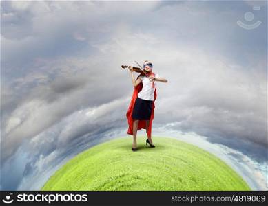 Young woman in super hero costume playing violin