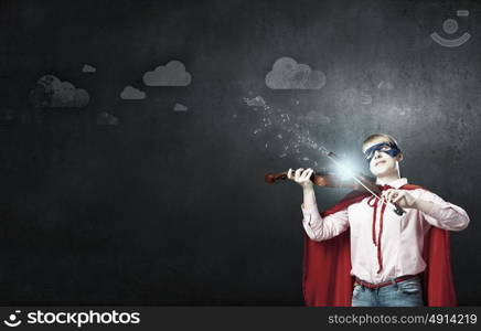 Young woman in super hero costume playing violin. She is super woman