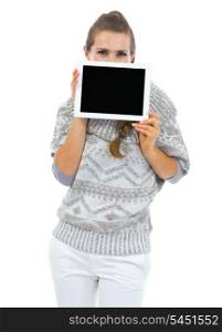 Young woman in sweater hiding behind tablet pc with blank screen