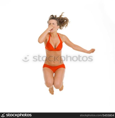 Young woman in swimsuit jumping in water