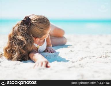 Young woman in swimsuit laying on beach . rear view