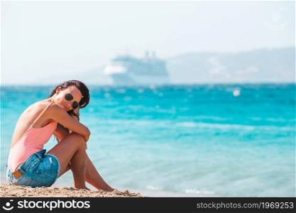 Young woman in swimsuit on the beach in Europe. Young beautiful woman on the beach during tropical summer vacation