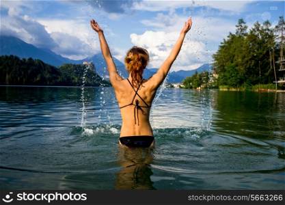 Young woman in swimwear standing in a mountain lake