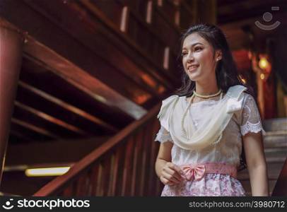 young woman in Thai traditional dress at wooden house