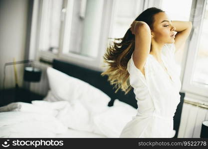 Young woman in the room gets out of bed