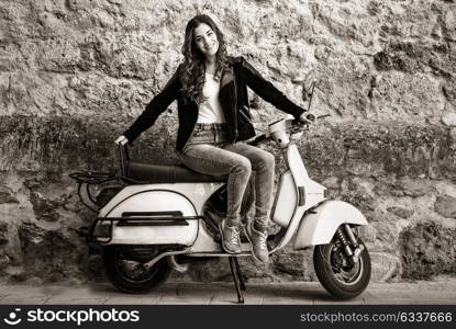 Young woman in urban background woman climb on a scooter motorcycle wearing casual clothes