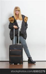 Young woman in warm jacket with suitcase. Gorgeous blonde tourist travel girl. Tourism.. Young woman in warm jacket with suitcase.
