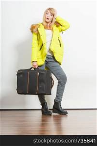 Young woman in warm jacket with suitcase. Gorgeous blonde tourist travel girl. Tourism.. Young woman in warm jacket with suitcase.