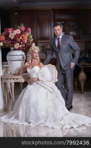 Young woman in wedding dress and man in the interior in retro style