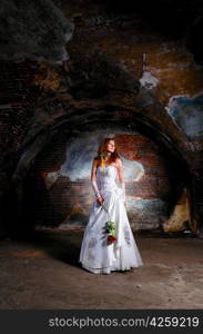 young woman in wedding dress at abandoned place