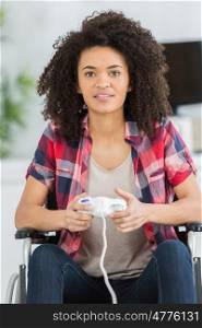 young woman in wheelchair playing video games at home