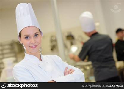 young woman in white chef dress with hat