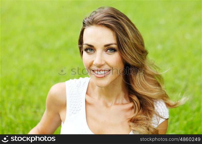 young woman in white dress lying on grass. beautiful young woman in white dress lying on grass