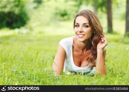 young woman in white dress lying on grass. beautiful young woman in white dress lying on grass