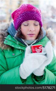 Young woman in winter outfit enjoy a coffee