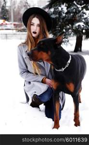 Young woman in winter park with dog having fun