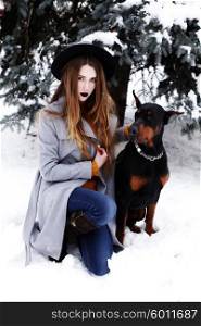 Young woman in winter park with dog having fun