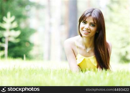 young woman in yellow dress lying on grass