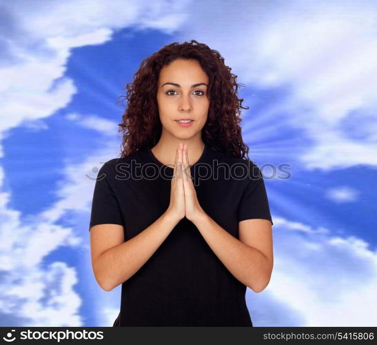 Young woman in yoga position with a blue sky of background