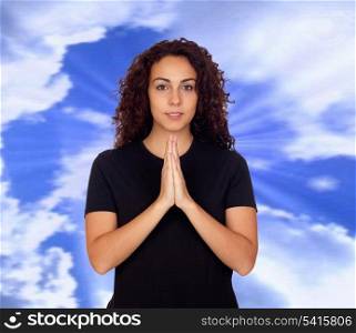 Young woman in yoga position with a blue sky of background