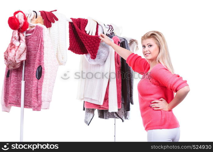 Young woman indecision in wardrobe home closet, teen blonde girl choosing her warm fashion outfit on clothing rack. Picking winter autumn clothes, shopping concept.. Woman in home closet choosing clothing, indecision