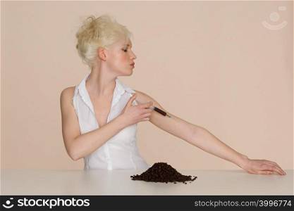 Young woman injecting coffee into her arm